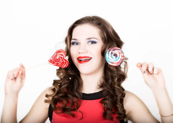 Retrato de mujer joven y hermosa con frenos dentales que sostienen el azucarillo — Foto de Stock