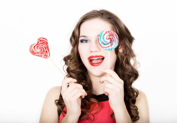 Porträt einer jungen schönen Frau mit Zahnspange, die Zuckerpflaume hält — Stockfoto