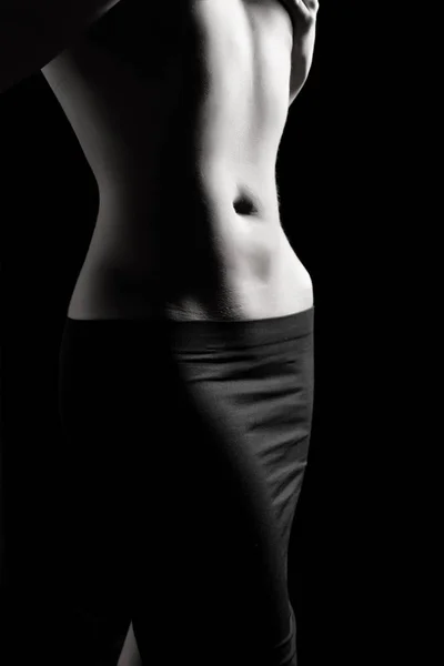Kobieta brzuchem i wzruszający młoda dziewczyna lekkoatletycznego na ciemnym tle — Zdjęcie stockowe
