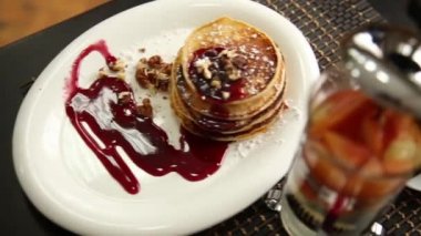 Ev yapımı tatlı krep meyve ile reçel, ekşi krema beyaz tabakta. Böğürtlenli reçel ve ceviz kahvaltı yığını ile tepesinde.