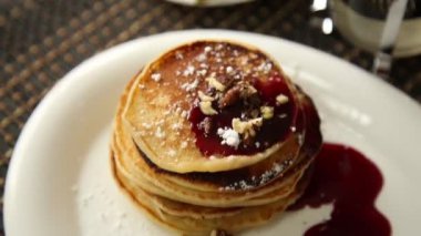 Ev yapımı tatlı krep meyve ile reçel, ekşi krema beyaz tabakta. Böğürtlenli reçel ve ceviz kahvaltı yığını ile tepesinde.