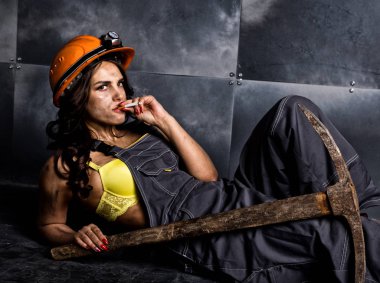 seksi kadın madenci işçi tulumlu çelik duvar ve yasaktır zemin katta oturan çıplak vücudunun üzerinde içinde kazma ile