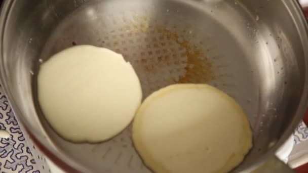 Cuoco prepari la colazione o il dessert, frigga frittelle su una gribble. Frittelle dolci fatte in casa con marmellata di frutta, panna acida su un piatto bianco . — Video Stock