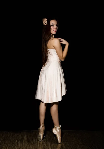 Joven bailarina con un cuerpo perfecto está bailando en zapatos puntiagudos sobre fondo oscuro — Foto de Stock