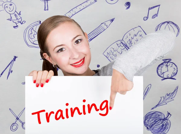 Młoda kobieta trzyma tablicę z pisania słowa: szkolenia. Technologia, internet, biznes i marketing. — Zdjęcie stockowe