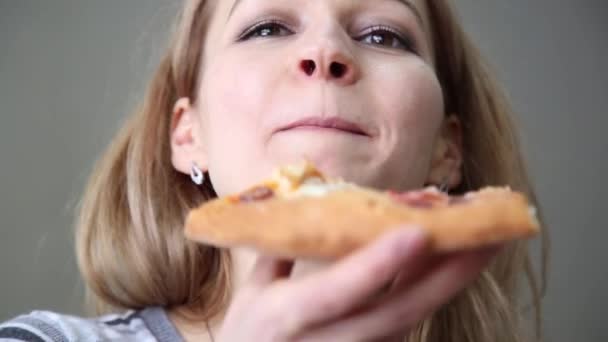 Leende trevlig dam som äter en pizza — Stockvideo