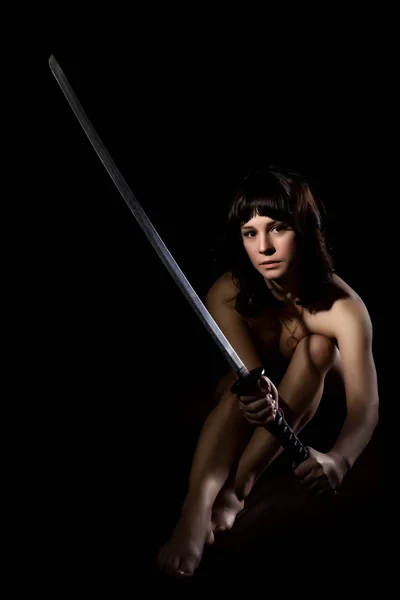 Sexig naken kvinna med svärd på mörk bakgrund — Stockfoto