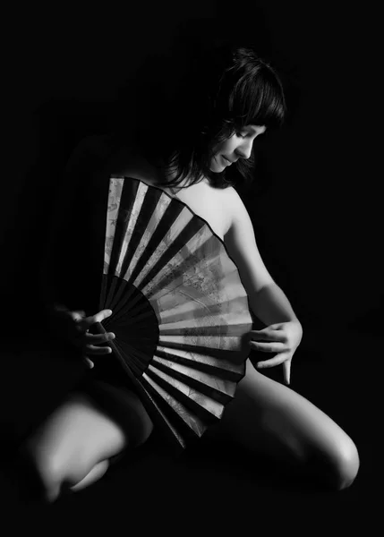Sexy femme nue tenant plaisir chinois sur fond sombre. noir et blanc — Photo