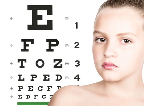 Fiatal lány teszt látás tábla mint háttér. megőrzése gyermek látás fogalma — Stock Fotó
