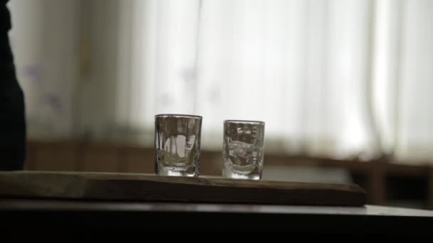 Homem sozinho derramando e rapidamente beber álcool de dois copos. alcoolismo masculino e depressão — Vídeo de Stock