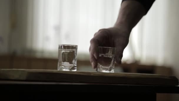 Man alleen gieten en snel het drinken van alcohol van twee glazen. mannelijke alcoholisme en depressie — Stockvideo