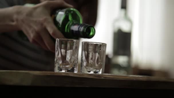 Mannen ensam hälla och snabbt dricka alkohol från två glasögon. manliga alkoholism och depression — Stockvideo