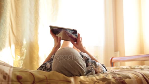Jong Arabisch meisje met tablet pc-computer op bed aan huis ... Jong Arabisch meisje met tablet pc-computer op bed aan huis ...