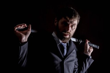 kılıçla koyu arka planda bir yün ceket kıç kızgın işadamı