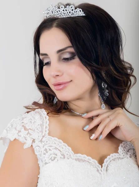 Bella giovane sposa indossa abito da sposa bianco con trucco professionale — Foto Stock