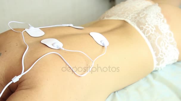 Professional electrotherapy on woman body. muscle contraction under the influence of an electric current. close-up of the patients back — Stock Video