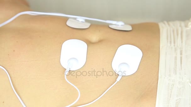 Professionele Fysiotechniek toegepast op het lichaam van de vrouw. de spiersamentrekking onder invloed van een elektrische stroom. Close-up patiënten maag — Stockvideo
