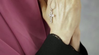 genç kadın başörtüsü dua ediyor. zincir bir haç ile tutarak yakın çekim eller