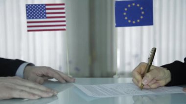 yabancı ortakları sözleşme imzalama. Yakın çekim eller ve erkek eli kalem ile. Uluslararası işadamı işbirliği