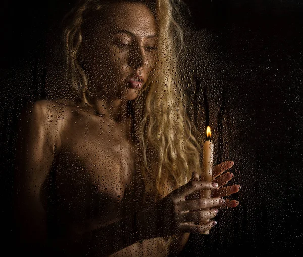 Bouclé nu femme blonde avec bougie sur fond sombre — Photo