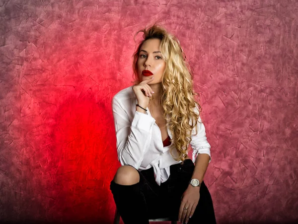 Attractive curly blonde woman sitting on stepladder — Stock Photo, Image