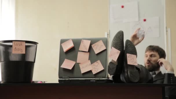 Last day at work, businessman in office throws papers in trash can, dreams of vacation — Stock Video