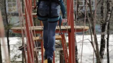 Genç kadın dağcı kolye günlük köprü ile yüksek halatlar sahası aşırı Park yürür