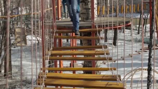 Młoda kobieta wspinacz idzie przez most dziennika wisiorek na linowy, extreme Park — Wideo stockowe