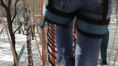 Genç kadın dağcı kolye halat köprü tarafından yüksek halatlar sahası aşırı Park yürür. Kaya tırmanma kavramı