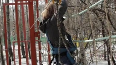 Genç kadın dağcı kolye halat köprü tarafından yüksek halatlar sahası aşırı Park yürür. Kaya tırmanma kavramı