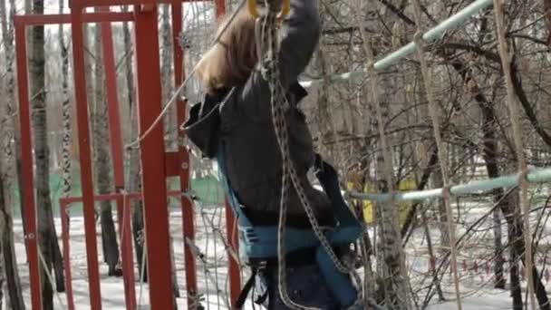 Jeune grimpeuse marche par pendentif pont de corde sur haut parcours de cordes dans le parc extrême. Concept d'escalade — Video