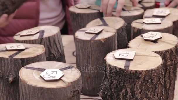 Young teenage girls playing on board game with numbers and firewood in backyard — Stock Video