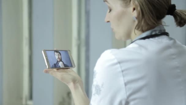 Consultas médicas en línea. paciente masculino video chat con el médico en el teléfono — Vídeo de stock