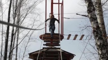 Genç kadın dağcı kolye günlük köprü ile yüksek halatlar sahası aşırı Park yürür