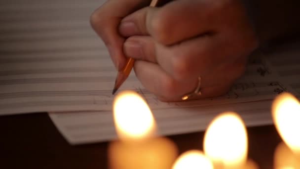 Student writing a music: musician composing with a pencil in a music book. musical staff — Stock Video