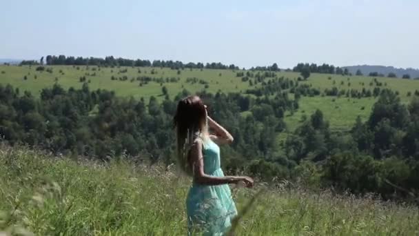 Молодая девушка вращается на зеленой траве, девушка в природе — стоковое видео