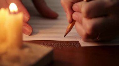 bir müzik yazma öğrenci: mum ışığı ile bir müzik kitapta bir kalem ile beste müzisyen. yakın çekim el müzisyen