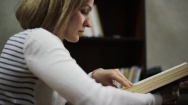 genç kadın Kitaplığı'nda büyük bir kitap okuma. raflardan kitapları ile