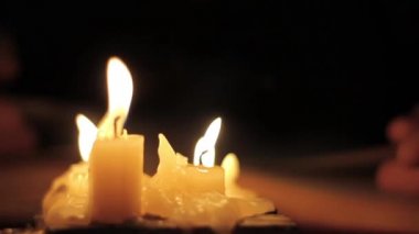 Kitap okuma ve bir sarı sayfalar eski dokunmadan bir adam. Karanlık odada mum ışığında