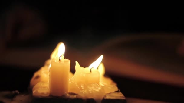 Homme lisant et touchant des pages jaunes de vieux livre. Lumière de la bougie dans la chambre noire — Video