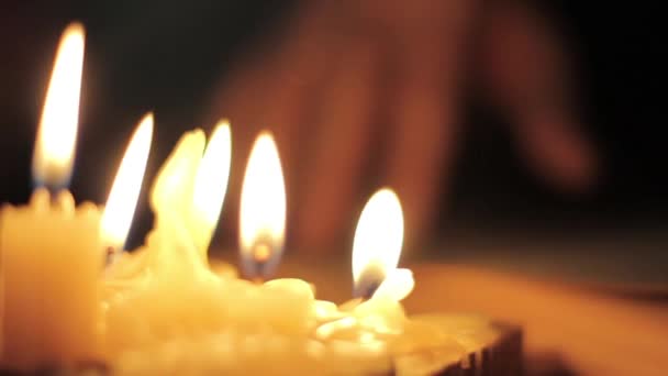 Un moine lisant et touchant des pages jaunes d'un vieux livre. Lumière de la bougie dans la chambre noire — Video