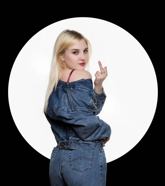 Widok z młoda kobieta w denim jaket tyłu i jeans pokazać środkowy palec, spierdalaj znak na białym tle. koncepcja nieprzyzwoite styl życia — Zdjęcie stockowe