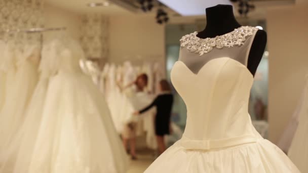 Detail figuríny s svatební šaty. Prodavač je pomoc pro výběr svatební šaty hezká mladá žena. Rozostřené pozadí. — Stock video