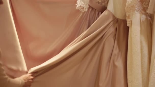 Shop asistent pomáhá pro výběr svatební šaty v obchodě svatební hezká mladá žena — Stock video