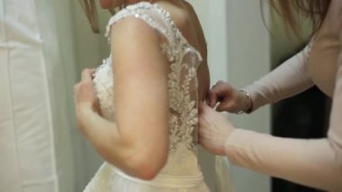 güzel kız gelin butik, tezgâhtar gelinlikle üzerinde çalışıyor Oda uydurma içinde Gelin için yardım