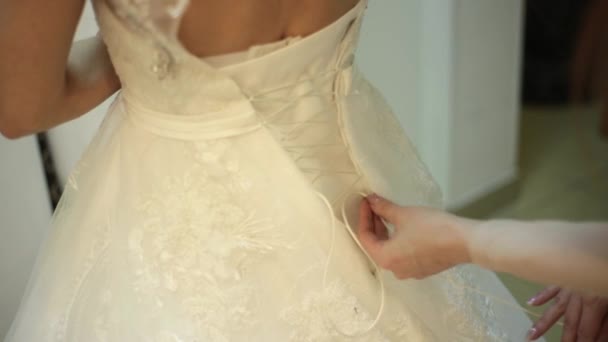 Подружка невесты кружева свадебное платье для красивой женщины Яунг в свадебном бутике, концепция подготовки свадьбы — стоковое видео