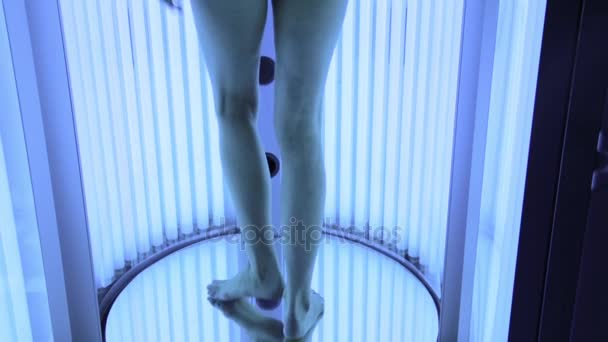 Fiatal nő fehér fehérnemű bathingsuit szolárium állni, és sunbathes a szalonban — Stock videók
