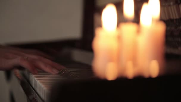 Play piano. female hands playing the piano of candle light. Fingers on the piano. — Stock Video