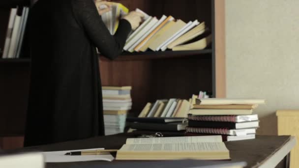 Fokussierte Studentin, die in einer Bibliothek der Universität mit Büchern arbeitet. Müder Student bereitet sich auf Prüfungen vor — Stockvideo