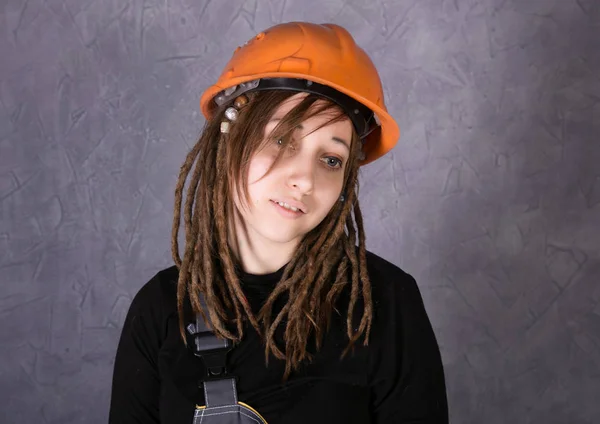 Девушка в защитном шлеме оранжевый жилет держит молоток инструмент — стоковое фото